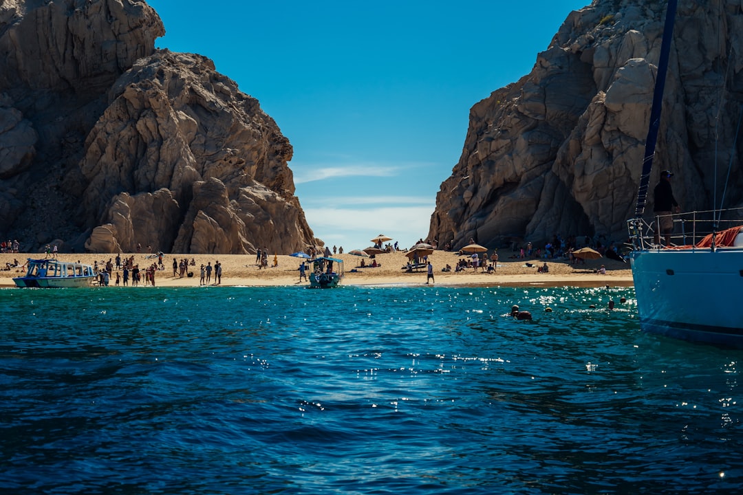 A breathtaking aerial view of the iconic El Arco rock formation in Cabo San Lucas, Mexico, surrounded by turquoise water, showcasing the region's powerful tourism appeal.