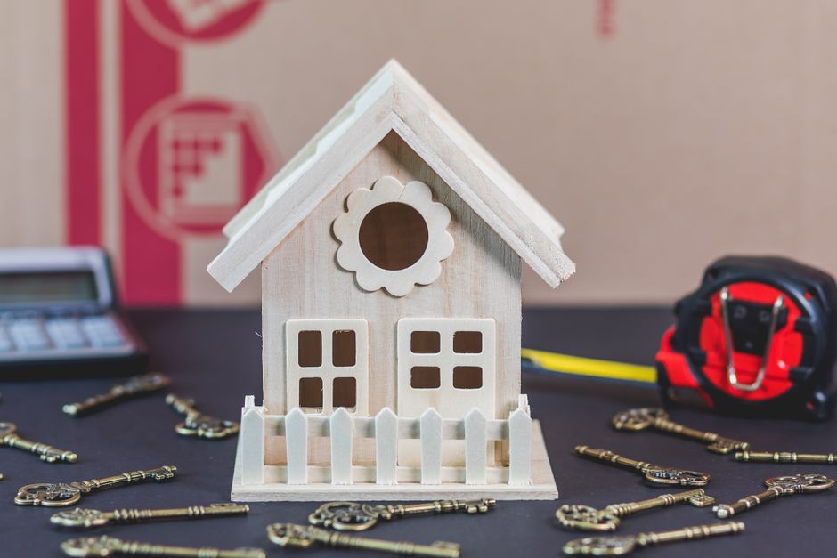 A clean flatlay of house keys, a pen, and legal documents neatly arranged on a wooden table, symbolizing the organizational checklist for inheriting a house.