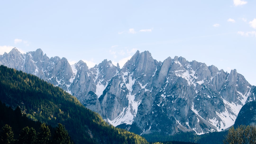 A sleek, modern laptop open on a desk with a stunning, bright view of the Colorado Rocky Mountains visible through a window, blending technology with nature.